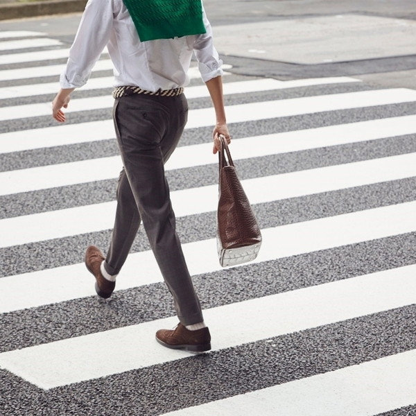 ホワイトシャツにサンドブラウンのパンツ。ブラウンのスエードシューズにトートバッグ